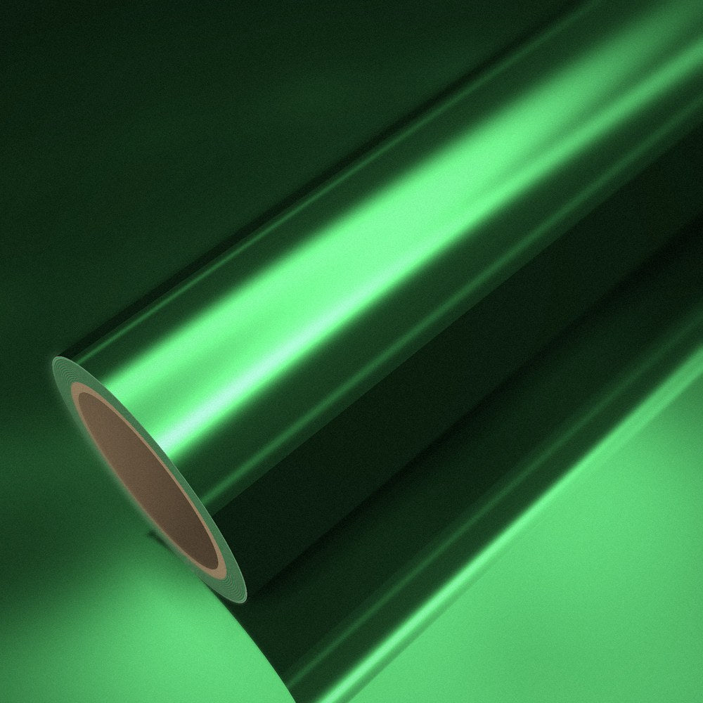 Rouleau de vinyle chrome vert posé sur une feuille du même vinyle