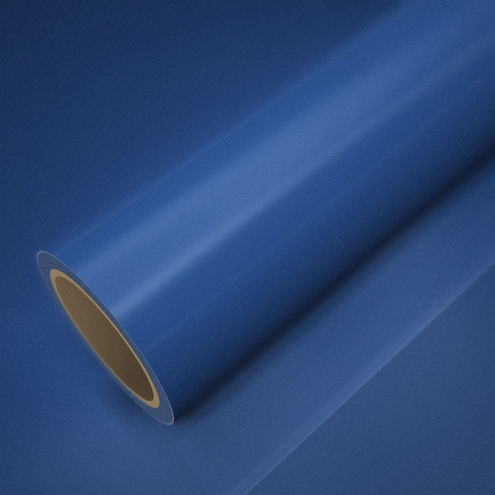 Rouleau de vinyle bleu clair brillant (style BMW) posé sur une feuille du même vinyle
