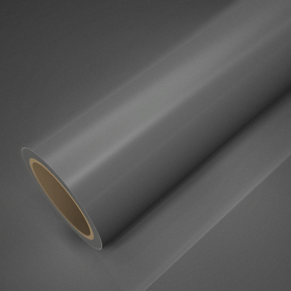 Rouleau de vinyle gris ciment brillant posé sur une feuille du même vinyle