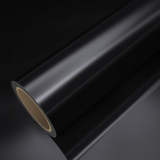 Rouleau de vinyle chrome noir posé sur une feuille du même vinyle