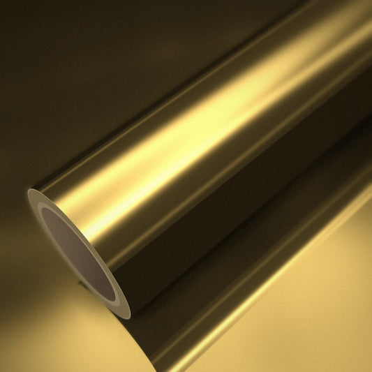 Rouleau de vinyle chrome or posé sur une feuille du même vinyle