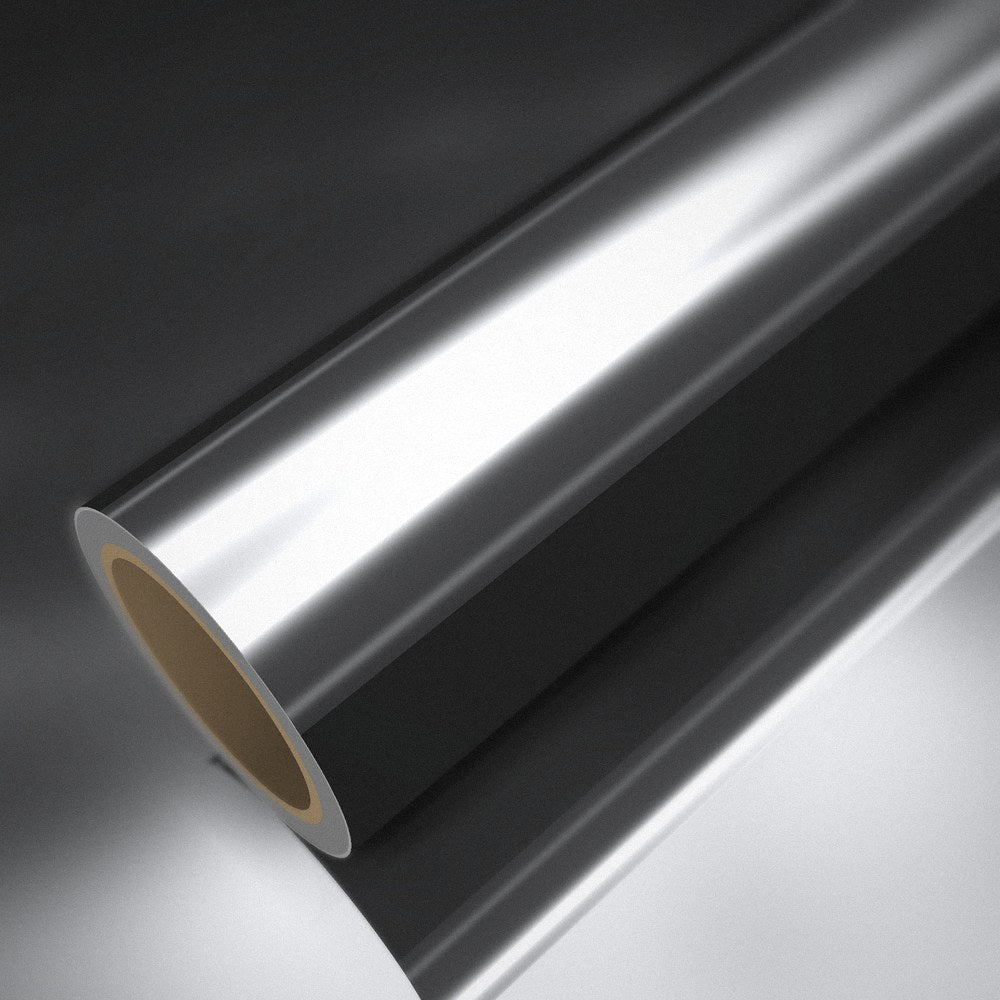 Rouleau de vinyle chrome argent posé sur une feuille du même vinyle