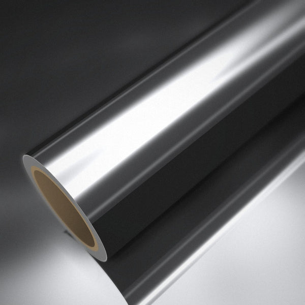 Rouleau de vinyle chrome argent posé sur une feuille du même vinyle