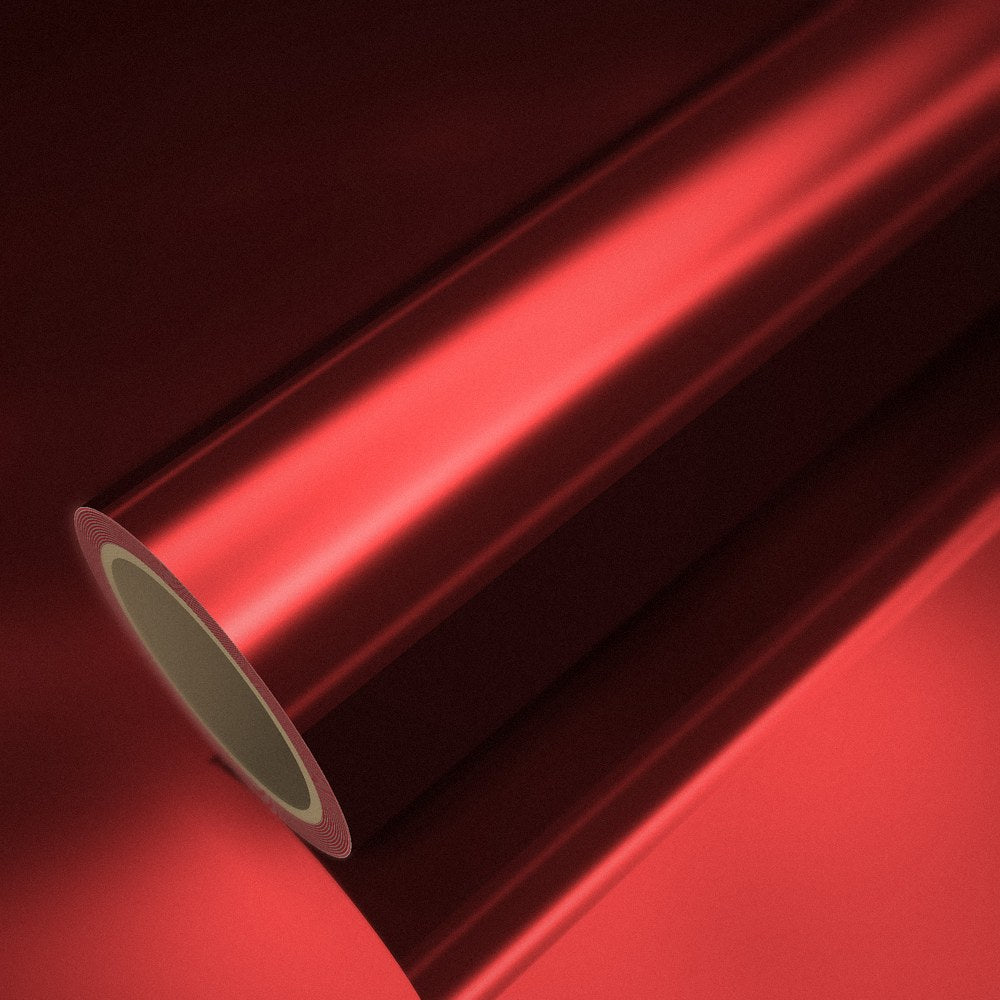 Rouleau de vinyle chrome rouge posé sur une feuille du même vinyle