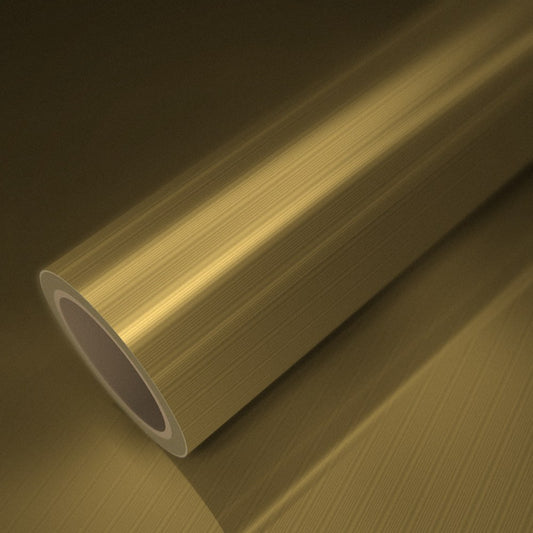 Rouleau de vinyle chrome mat or brossé posé sur une feuille du même vinyle