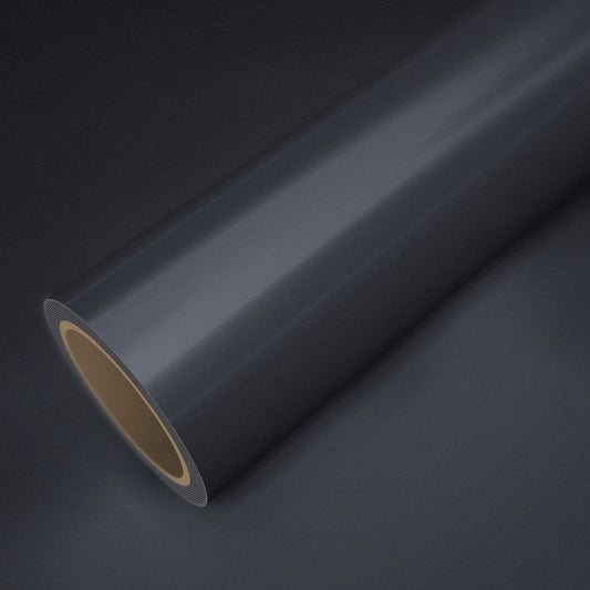 Rouleau de vinyle chrome satiné gunmetal posé sur une feuille du même vinyle
