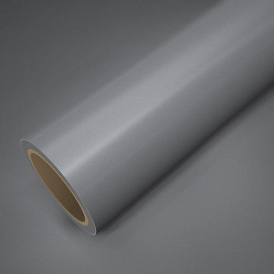 Rouleau de vinyle argent brillant posé sur une feuille du même vinyle