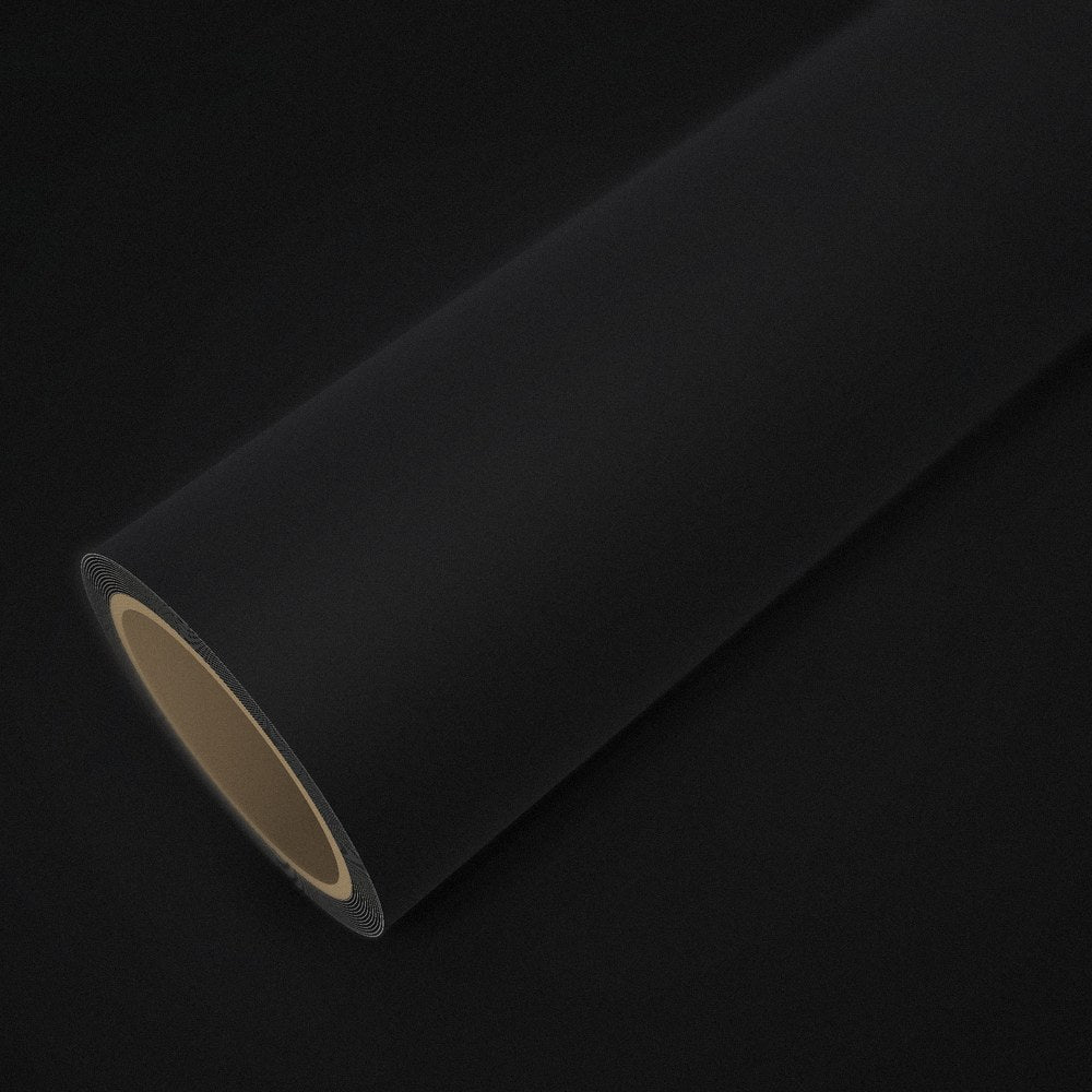 Rouleau de vinyle noir mat posé sur une feuille du même vinyle