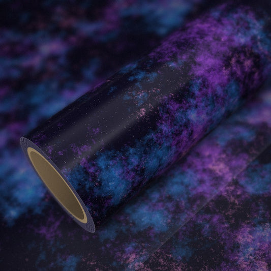 Rouleau de vinyle galaxie posé sur une feuille du même vinyle