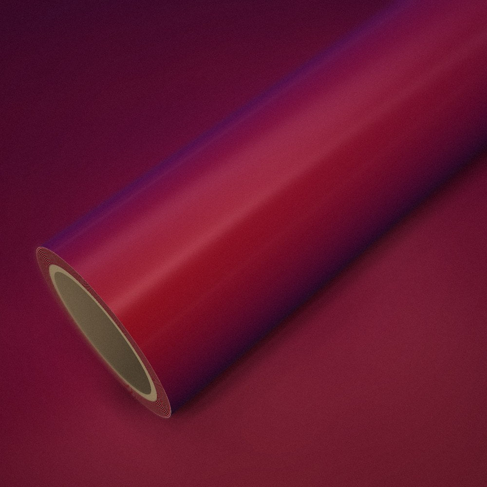 Rouleau de vinyle rouge magique (color flip) posé sur une feuille du même vinyle