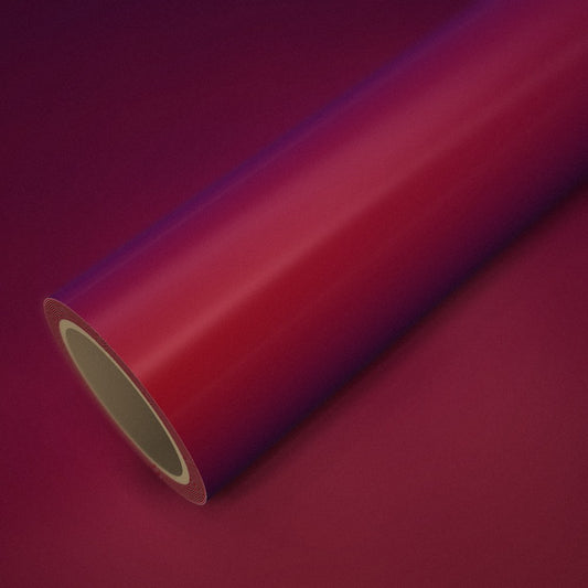 Rouleau de vinyle rouge magique (color flip) posé sur une feuille du même vinyle