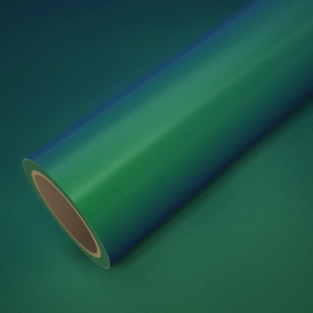 Rouleau de vinyle vert magique (color flip) posé sur une feuille du même vinyle