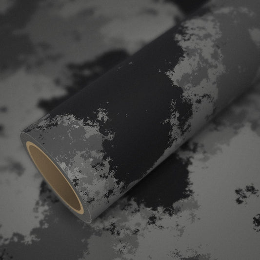 Rouleau de vinyle camouflage urbain posé sur une feuille du même vinyle